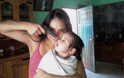 Fegyverrel viccelődik a kisbabájával